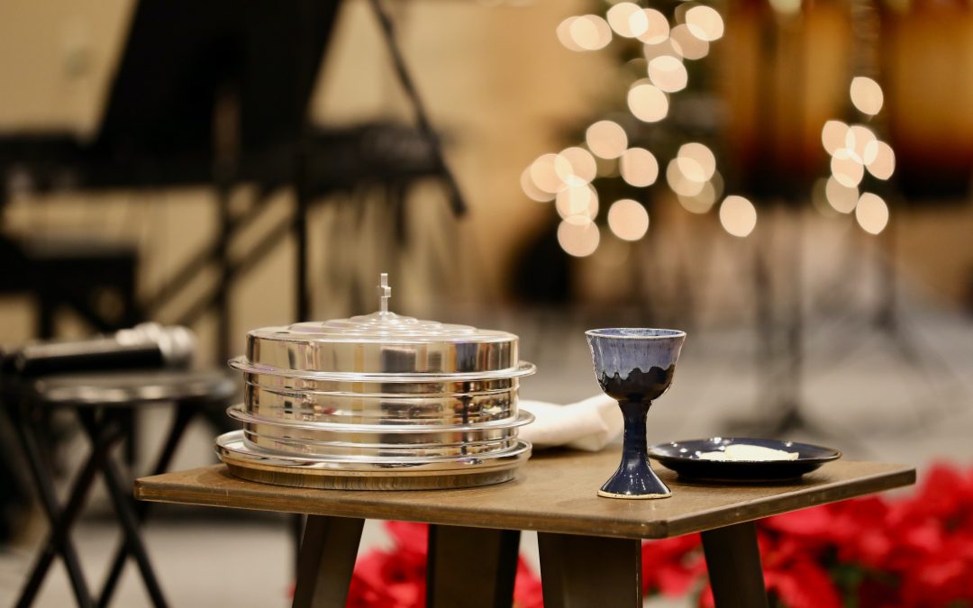 A silver dish and chalice sit on the table for communion.
